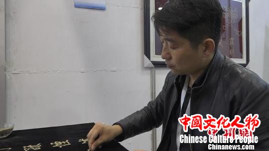 王修雷展示传统的沙书技艺 张俊 摄